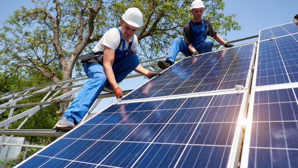 Trabajadores Trabajadores Instalando Páneles solares sobre una estructura metálica